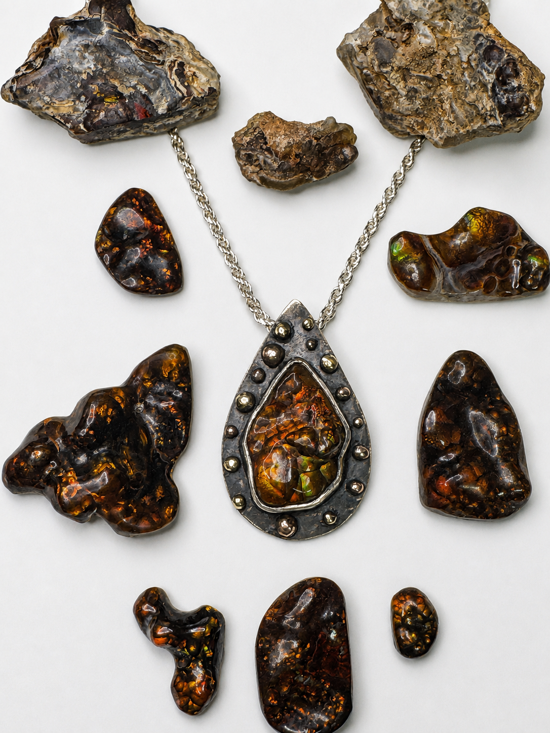 Fire agate rough, carved stones and a fabricated pendant