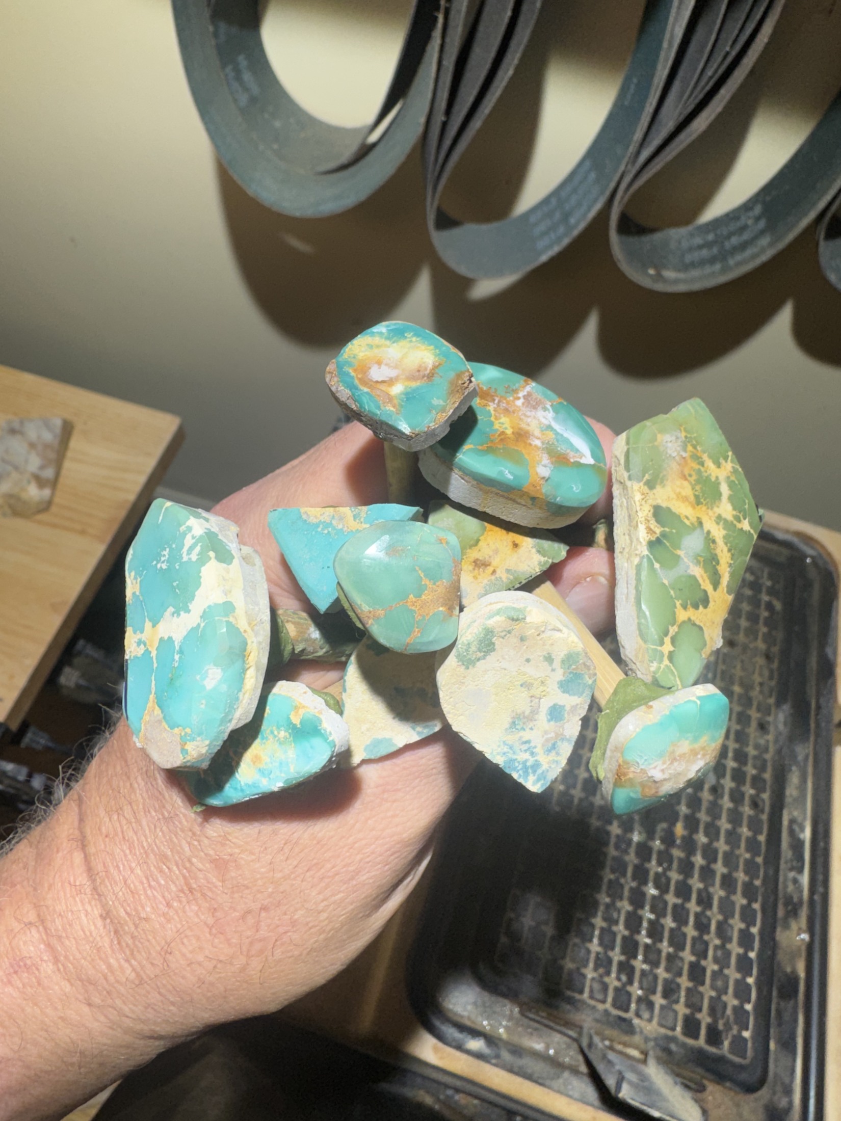Turquoise rubs secured to dop sticks during shaping